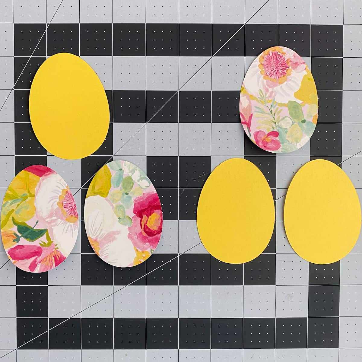 Floral and yellow egg objects on a grid background
