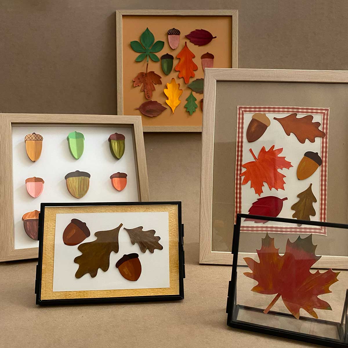 Framed autumn-themed artwork with leaves and acorns on a neutral background to showcase a Cakewalk DIY Paper Craft tutorial.
