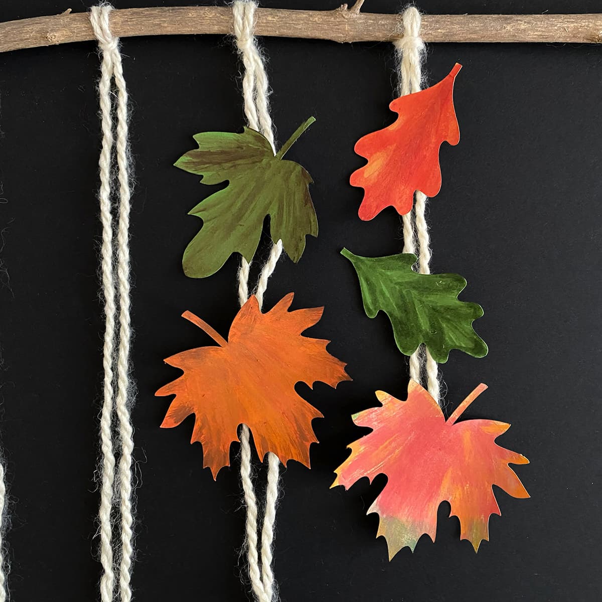 Lengths of yarn with 2-3 arranged leaves for DIY leaf mobile, showcasing variety from Cakewalk DIY Paper Craft tutorial.